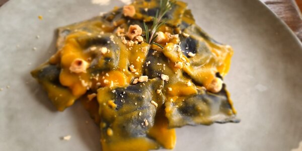 Ravioli di brasato al carbone, con salsa alla zucca, nocciole e spolverata di nostrano