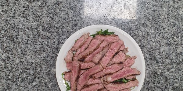 Tagliata di manzo agli aromi su letto di rucola