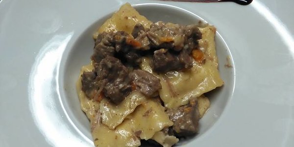 Ravioli al brasato di manzo con la sua salsa e ciuffi di ricotta salata
